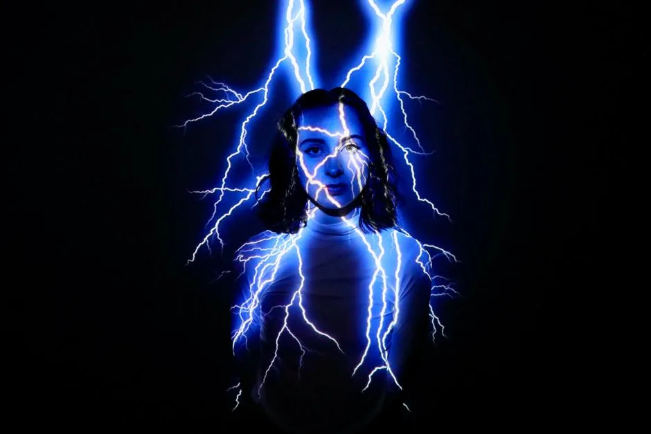 A creative and ethereal studio portrait of a woman with lightning projection on a black background.